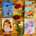 Patru romane de ficțiune de la Editura Trei așezate pe un fundal rustic de lemn, alături de trandafiri roșii și flori albe, ideale pentru mărțișor și Ziua Femeii.