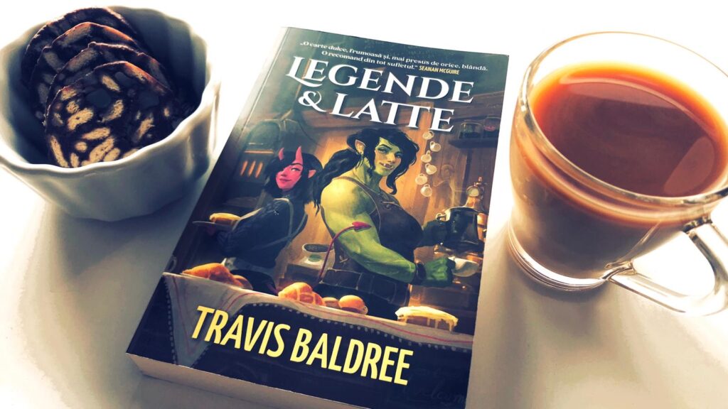 Romanul Legende & latte incadrad de un castronel cu câteva felii de salam de biscuiți si o ceasca de cafea cu lapte