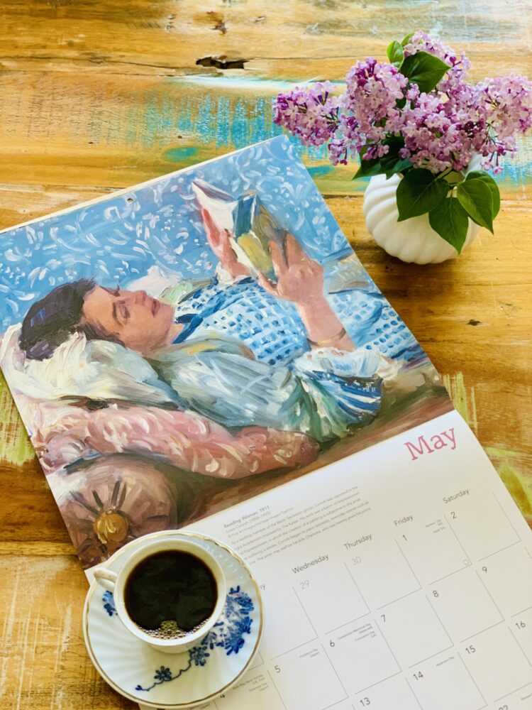 Cadru de relaxare cu o ceașcă de cafea, liliac mov și calendarul cu pictura Femeia care citește de Lovis Corinth