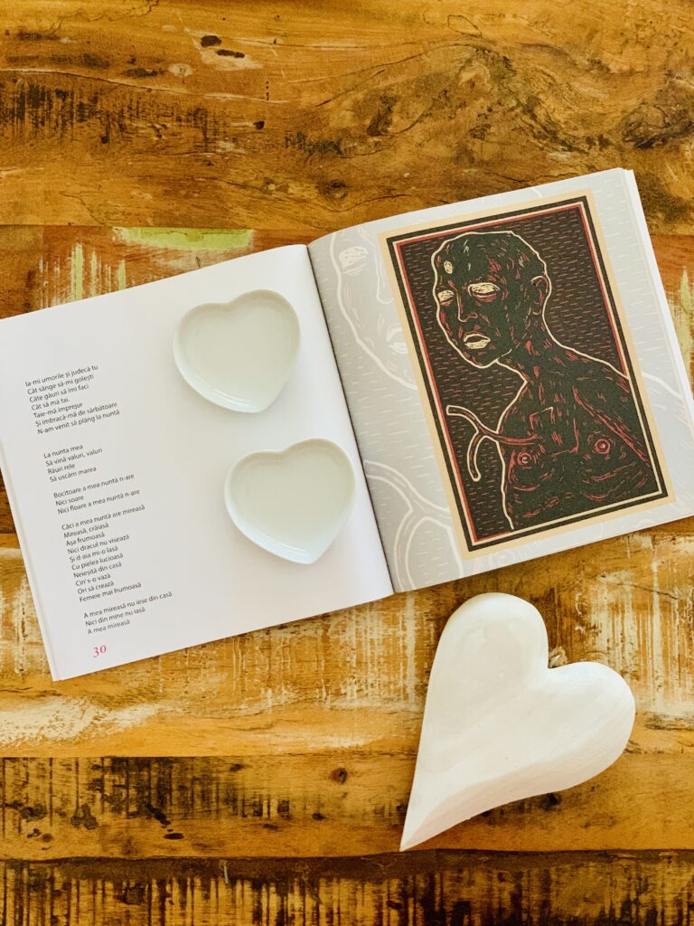 Detaliu cu pagini deschise și versuri tulburătoare din volumul de poezie „Odă Racului” de Andrei Coca, Editura Vremea, așezat pe fundal de lemn rustic.