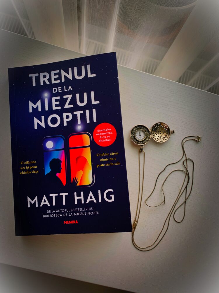 Coperta cartii Trenul de la miezul noptii de Matt Haig editia Nemira asezata pe o masa alba langa un ceas de buzunar cu lant