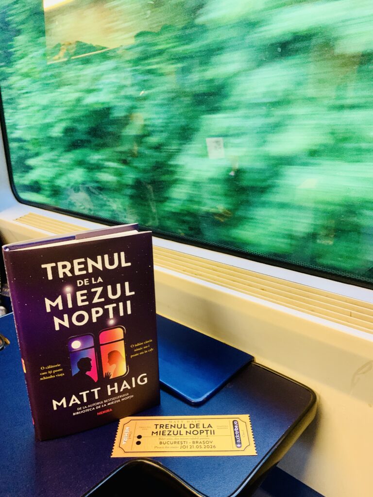 Romanul Trenul de la miezul noptii de Matt Haig si un bilet de tren simbolic pe masuta din interiorul unui tren aflat in miscare