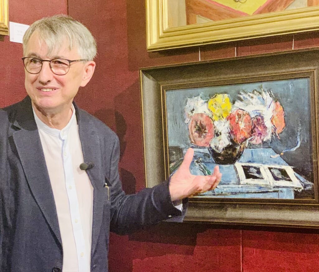 Horia-Roman Patapievici prezentând tabloul Natură statică cu anemone și album de artă de Gheorghe Petrașcu la Artmark