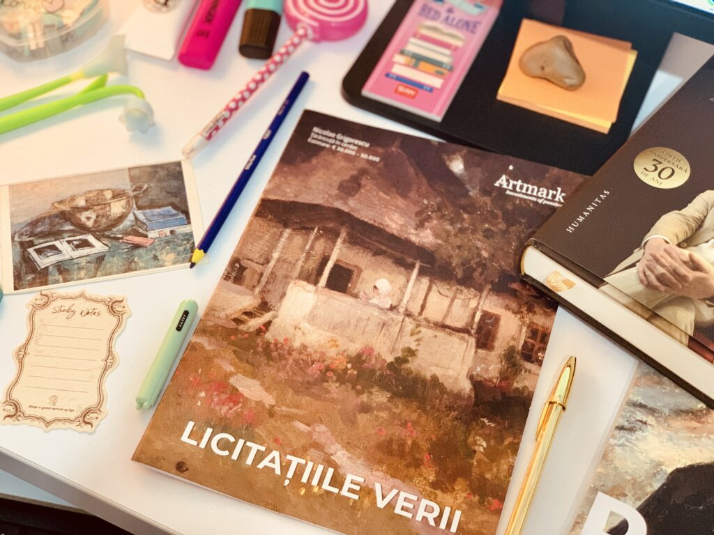 Biroul de lucru cu catalogul Artmark și cartea poștală din copilărie cu reproducerea unui tablou de Gheorghe Petrașcu