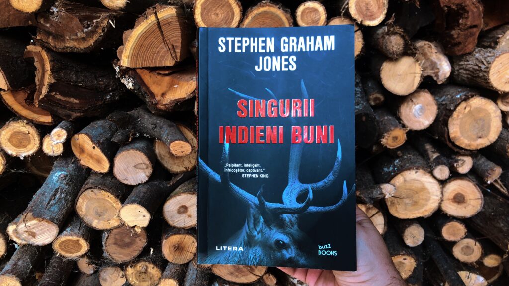 Romanul Singurii indieni buni de Stephen Graham Jones, apărut la Editura Litera, în fața unei gramezi de lemne tăiate